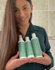 Smiling woman showcasing results from Hydrate shampoo and conditioner and Seal and Shine leave-in conditioner