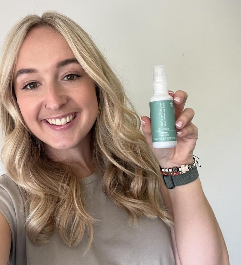 Gorgeous woman holding a bottle of Tints of Nature Structure treatment, after using the protein treatment.