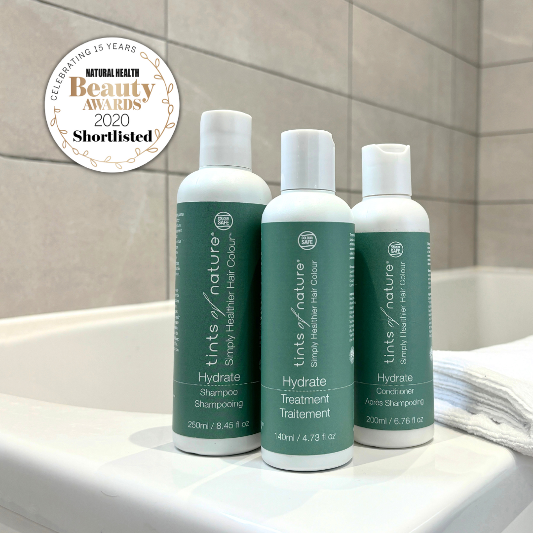 Vegan hair care set: trio of shampoo, conditioner, and treatment on bathtub with Natural Health Beauty Awards 2020 Shortlisted logo..